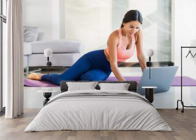 Young fit woman doing yoga at home. Wall mural